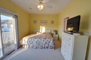 a bedroom with a bed and a flat screen tv at Sea Star Village 314 in Surf City