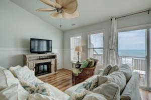 een woonkamer met een bank en een televisie bij 1906-B S Shore Drive - Beg T' Go in Watts Landing