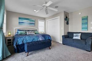 a bedroom with a bed and a blue couch at 3950 Island Drive in North Topsail Beach