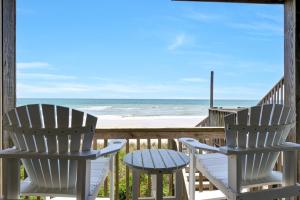 two chairs and a table on a porch overlooking the beach at 3950 Island Drive in North Topsail Beach