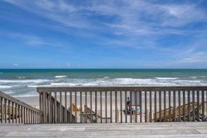 a person standing on the beach with a surfboard at 3952 Island Drive in North Topsail Beach +30 photos