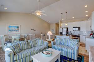 a living room with two couches and a kitchen at Sea Star Village 320 in West Onslow Beach