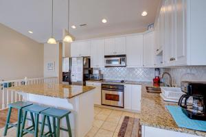 a kitchen with white cabinets and two blue stools at Sea Star Village 320 in West Onslow Beach +25 photos