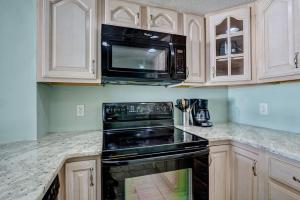 a kitchen with a black stove and a microwave at St Regis 1504 in Chadwick Acres