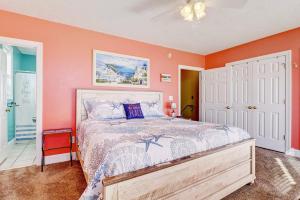 a bedroom with a bed with an orange wall at 3970 Island Drive - It's a Wonderful Life in North Topsail Beach