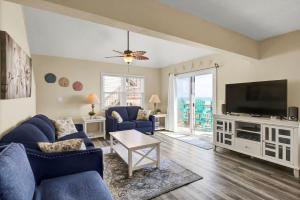 a living room with blue furniture and a flat screen tv at 3958 Island Drive in North Topsail Beach