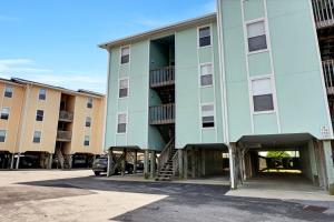 a green building with a spiral staircase in a parking lot at Surf Condos 737 in Surf City +34 photos