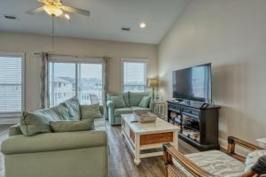 a living room with a couch and a flat screen tv at Sea Star Village 212 in Surf City