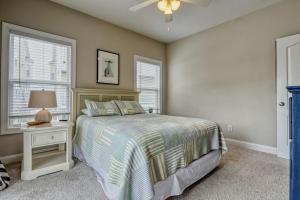 a bedroom with a bed and a lamp and windows at Sea Star Village 212 in Surf City