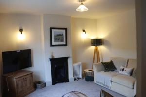 a living room with a couch and a tv at Brewe's Loft in Farden