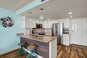 a kitchen with white cabinets and a counter with stools at St Regis 1105 in Chadwick Acres +41 photos