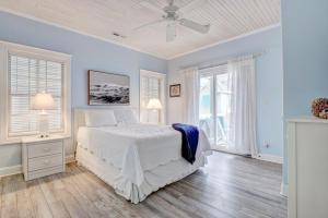 ノース・トップセール・ビーチにある4426 Island Drive - Saltwater Therapyの白いベッドと2つの窓がある寝室