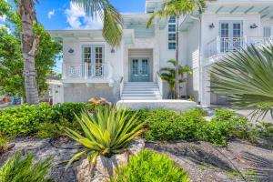 a white house with palm trees in front of it at Beach Fanta Sea - 149 in Bailey Hall