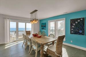 a dining room with a table and chairs and the ocean at 4444 Island Drive - Seahorse Sanctuary in North Topsail Beach +41 photos