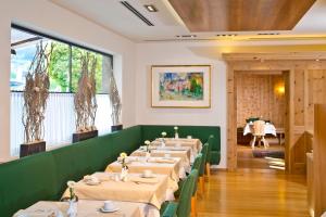 a row of tables in a dining room with a table set at Hotel Maximilian - Stadthaus Penz in Innsbruck