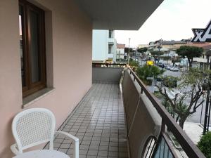 ein Balkon mit zwei Stühlen und einem Tisch auf einem Gebäude in der Unterkunft Panorama suite-Appartamento affitto estivo in Alba Adriatica