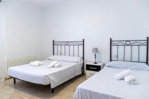 two beds in a bedroom with white sheets and towels at CT 355 AL - Faro's Pechina Rural - Disfruta de un Cortijo! in Pechina