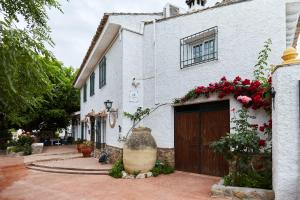 a white house with flowers on the side of it at Alojamiento Rural Marien in La Bobadilla