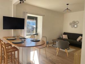a living room with a table and a couch at Appartement à la campagne in Flavin