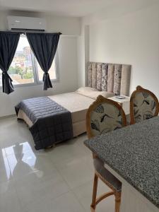 Un dormitorio con una cama y una mesa y sillas. en Luna centro, en Neuquén