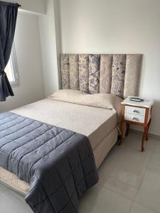 Un dormitorio con una cama grande y una mesita de noche. en Luna centro, en Neuquén