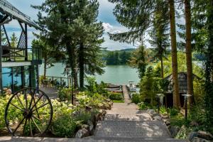 a garden with a stone path next to a lake at Tawerna Kaszubska in Ostrzyce