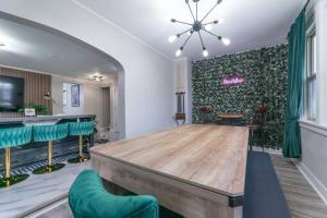 una sala de conferencias con mesa de madera y sillas verdes en Pool Table, Arcade, Darts, 3 Car Garage, Sleeps 20, en Milwaukee