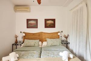 a bedroom with a bed with a wooden headboard at Alojamiento Rural Marien in La Bobadilla +35 photos