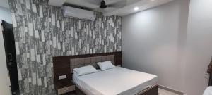 a bedroom with a white bed and a wall at Hotel Shri Vishwanath in Varanasi