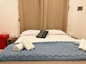 a bed with a blue blanket and pillows on it at Luxury 5BR , 4BA Penthouse In the City Center in Cagliari