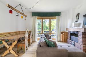 a living room with a table and a couch at Garden Apartment Relax in Barco