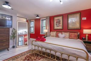 Un dormitorio con una cama grande con paredes rojas. en Pool Table, Arcade, Darts, 3 Car Garage, Sleeps 20, en Milwaukee