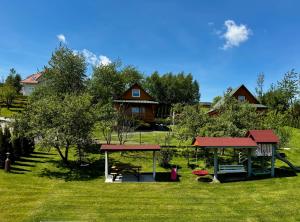 a park with a picnic shelter and a house at Bieszczadzki Zakątek 787-899-185 in Bukowiec