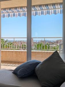 a bed with two pillows in front of a window at Vive Santa Pola - Relax y tranquilidad junto al mar in Santa Pola