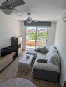 a living room with two beds and a flat screen tv at Vive Santa Pola - Relax y tranquilidad junto al mar in Santa Pola