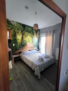 a bedroom with a bed with a mural on the wall at Elli's House in Keramoti