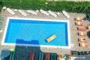 una vista dall'alto di una piscina con sedie e ombrelloni di Hotel Stradiot a Rimini