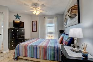 a bedroom with a bed and a dresser and a television at Relaxing oceanfront 1 Bedroom Condo in St. Regis Resort in Chadwick Acres