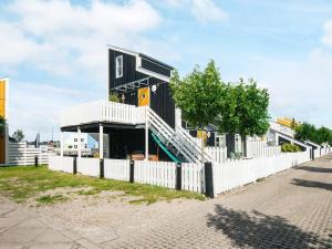 a black house with a white fence at 7 person holiday home in Ebeltoft in Ebeltoft