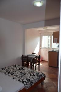 une pièce avec une table et des chaises et une cuisine dans l'établissement Apartmani Mulic, à Sutomore