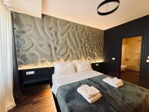 a bedroom with a bed with two towels on it at Tirana Central Rooms in Tirana