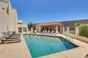 哈瓦苏湖城Island Condo with Pool Access in Lake Havasu City!的一个带躺椅的游泳池以及一座房子