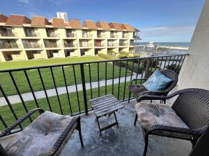 einen Balkon mit Stühlen, einem Tisch und einem Gebäude in der Unterkunft Gulfside Townhome 6 townhouse in Gulf Shores