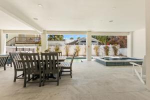 Un patio con sillas y una mesa y una piscina. en Akoya House at The Gemma by Brightwild, en Clearwater Beach