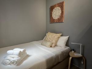 ein kleines Schlafzimmer mit einem Bett mit Handtüchern darauf in der Unterkunft Apartment 4 rooms Fira Barcelona in Hospitalet de Llobregat