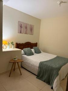a bedroom with a large bed and a table at Sana - Chácara Canto do Tiê - 15 hospedes in Casimiro de Abreu