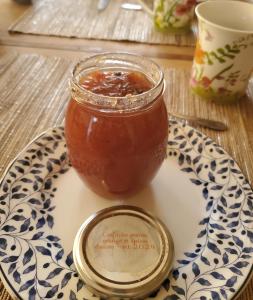 a jar of barbecue sauce sitting on a plate at Le Jardin des Papillons, gîte et chambre d'hôtes à Saint Fraimbault in Saint-Fraimbault