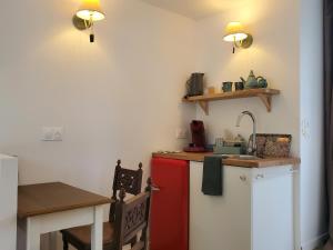 a kitchen with a red refrigerator and a table at Le Jardin des Papillons, gîte et chambre d'hôtes à Saint Fraimbault in Saint-Fraimbault +9 photos