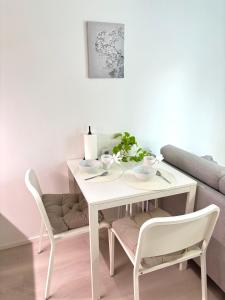 une table de salle à manger blanche avec deux chaises et une table dans l'établissement Foliate Living Nuppu, à Jyväskylä