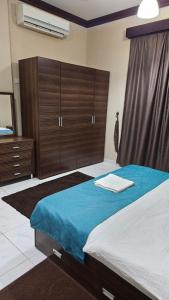 a bedroom with a large bed with wooden cabinets at فندق عين مجان للشقق الفندقية in ‘Ibrī +19 photos